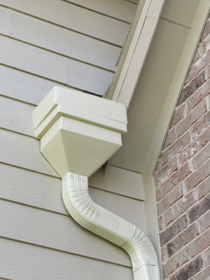 white rainwater downspout collection box installed on residential gutter system